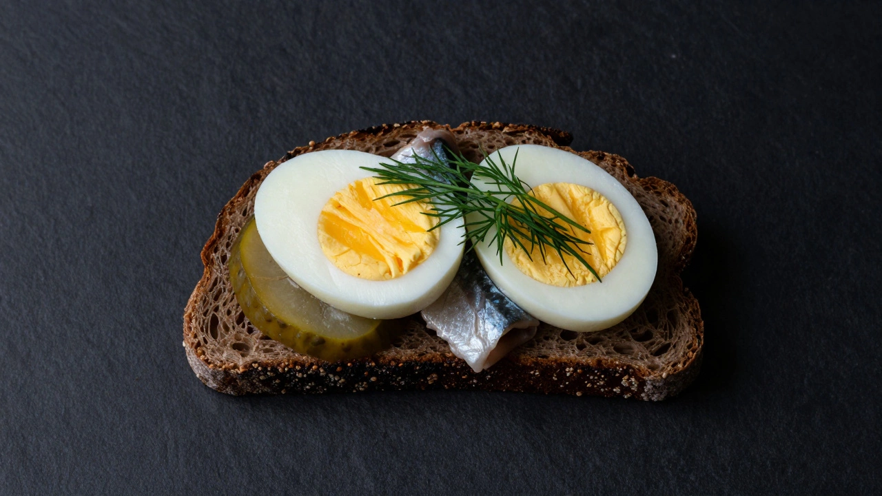 A Danish open-faced Smørrebrød with egg and pickled herring on dark rye bread